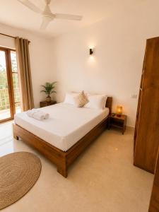 a bedroom with a bed with white sheets and a window at Smile Boutique Beach hotel in Nungwi