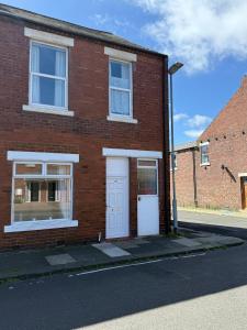 a brick house with a white door and a street at Plessey Road LARGE 5 Bed, 2 Bath, Contractors NEW in Cowpen