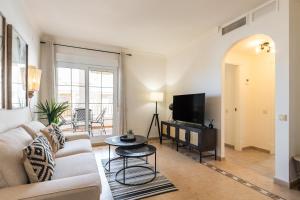 a living room with a couch and a tv at Las Dunas by Ĥ in Isla del Moral
