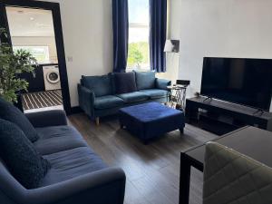 a living room with couches and a flat screen tv at Plessey Road LARGE 5 Bed, 2 Bath, Contractors NEW in Cowpen