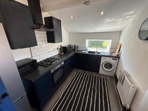 a small kitchen with a sink and a washing machine at Plessey Road LARGE 5 Bed, 2 Bath, Contractors NEW in Cowpen