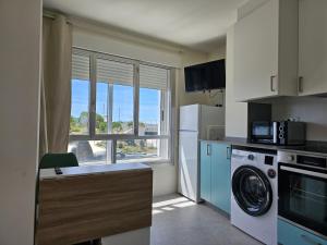 a kitchen with a washing machine and a window at Apartamentos Casa Albino in Sanxenxo