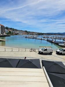 two cars parked in a parking lot next to a marina at Apartamentos Casa Albino in Sanxenxo