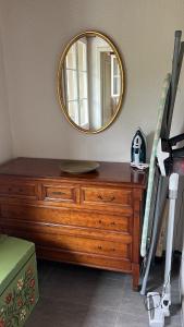 a wooden dresser with a mirror on top of it at Simple flat 72 m2 in the centre of Burgdorf with private parking in Burgdorf +8 photos