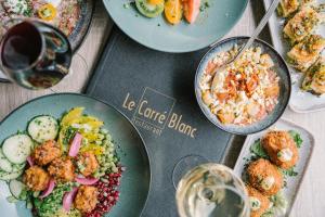 a table with plates of food and glasses of wine at BRIT HOTEL - RESTAURANT Saint-Brieuc Langueux in Langueux