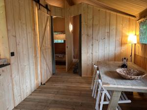 a room with a table and chairs in a cabin at Minicamping Het Zuiderscheveld in Hollandscheveld +20 photos
