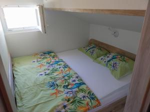 a small room with a bed and two pillows at Apartmani Lalu in Rtina