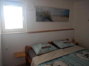 two beds in a room with a window and a bedskirtspectspectspectspects at Apartmani Lalu in Rtina
