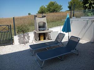 two chairs and an umbrella next to a grill at Apartmani Lalu in Rtina