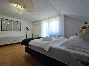 a bedroom with a bed with white sheets and a window at Villa Aylin in Bihać