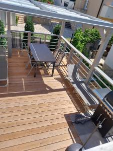 a wooden deck with a table and chairs on it at Apartmani Lalu in Rtina
