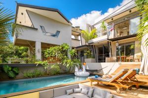a villa with a swimming pool and a house at Villa Mauritius - Designer Private Studios in Pointe aux Sable