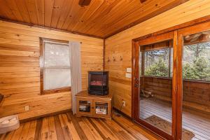 a room with a television and a window in a cabin at Dragonfly Cabin in Bryson City