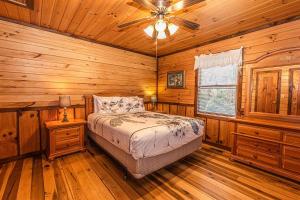 a bedroom with a bed and a ceiling fan at Dragonfly Cabin in Bryson City