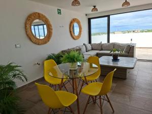 a living room with a table and yellow chairs at Playa del Carmen - Playaquerida in Playa del Carmen