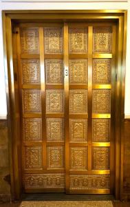 a pair of wooden doors with gold designs on them at Sports Illustrated Resorts Chicago in Chicago