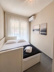 a large bed in a room with a window at Olea Luxury Living in Nea Fokea