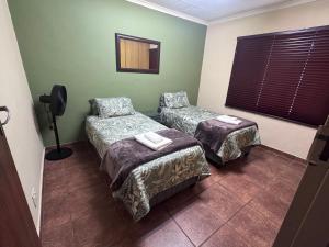 a hotel room with two beds and a window at Kalahari Hotel in Olifantshoek