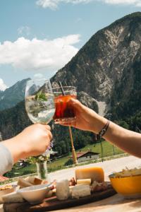 a person holding a glass of wine at a table at Càdor Hotel in Valle di Cadore