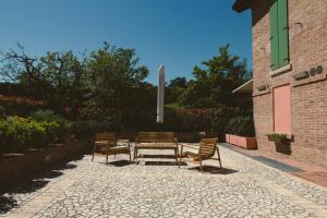 a group of chairs and tables on a patio at La Ruota Rooms in Casalgrande