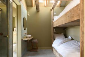 a bedroom with a bunk bed and a bathroom at Walingsuites in Holwerd