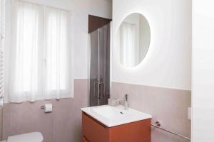 a bathroom with a sink and a mirror and a toilet at La Ruota Rooms in Casalgrande