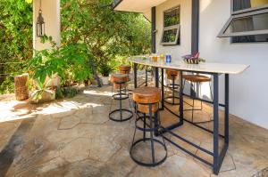 a patio with a bar with stools at Villa Mauritius - Designer Private Studios in Pointe aux Sable