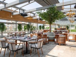 a restaurant with tables and chairs and windows at Swissotel Living Jeddah in Jeddah
