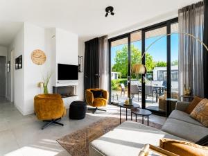 a living room with a couch and a tv at Harderwold Villa - 412 in Zeewolde