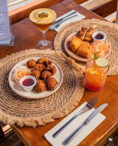 a table with two plates of food and a drink at Hotel Ti' Pelican in Saint-Pierre
