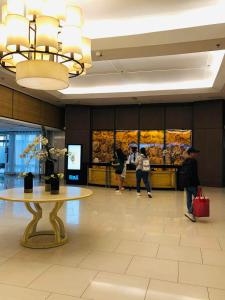 a lobby with a table and people in a building at Accommodating Place in Manila