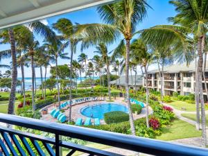 a view from the balcony of a resort with a pool and palm trees at 3-Bed Villa 309 at Turtle Bay in Kahuku