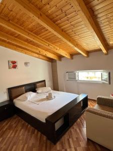 a bedroom with a large bed and a couch at Guest House Elisabeta in Përmet