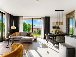 a living room with a couch and a table at Harderwold Villa - 412 in Zeewolde