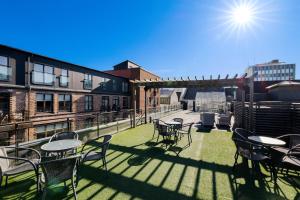 a patio with tables and chairs on a balcony at Kongens Gate Rooms in Kristiansand