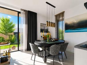 a dining room with a black table and chairs at Harderwold Villa - 412 in Zeewolde