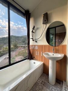a bathroom with a tub and a sink and a mirror at สะปันไลฟ์ in Ban Huai Ti