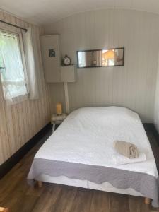 a bedroom with a large bed with white sheets at Le wagon roulotte in Thorigny-sur-Marne