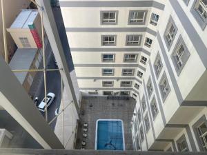 an overhead view of a tall building with a blue door at Ruru Tower Luxury Apartment in Juffair