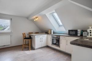 a kitchen with white cabinets and a stove top oven at Ferienwohnung 1 in Gribow +14 photos