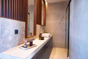 a bathroom with a sink and a shower at Kastri Beach Suites in Faliraki +23 photos