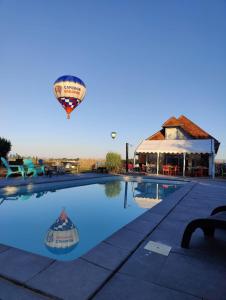 a hot air balloon flying over a swimming pool at Lodge Tipi, L'Indienne in Arc-et-Senans