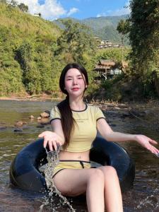 a woman is sitting in an inner tube in the water at สะปันไลฟ์ in Ban Huai Ti