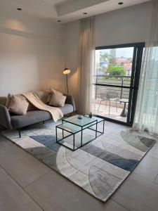 a living room with a couch and a glass table at QUATTRO-Sky Suites in Accra