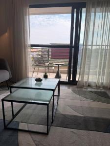 a living room with a table and a large window at QUATTRO-Sky Suites in Accra