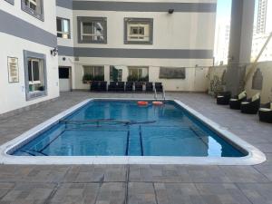 a swimming pool in the courtyard of a building at Ruru Tower Luxury Apartment in Juffair