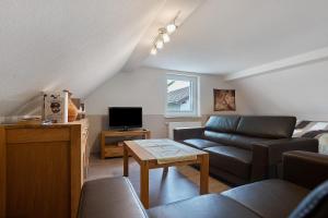 a living room with a couch and a tv at Ferienwohnung 1 in Gribow