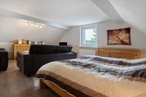 a bedroom with a bed and a couch and a window at Ferienwohnung 1 in Gribow