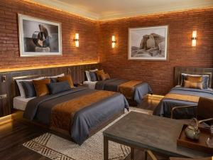 a room with three beds in a brick wall at Anadolu Hotel & Restaurant & Spa in Batumi