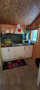 a small kitchen with white cabinets and a window at Chalet de la Grave in LʼEscarène